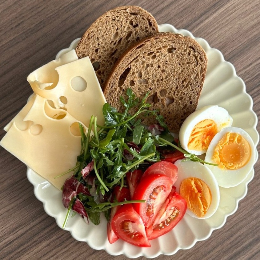 Тарелка с цельнозерновым хлебом, сыром и яйцом